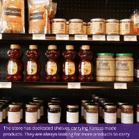 Image of Kansas made products including honey, sauerkraut, and more on the shelves at PrairieLand Market. Text at the bottom of the image reads: The store has dedicated shelves carrying Kansas made products. They are always looking for more products to carry.
